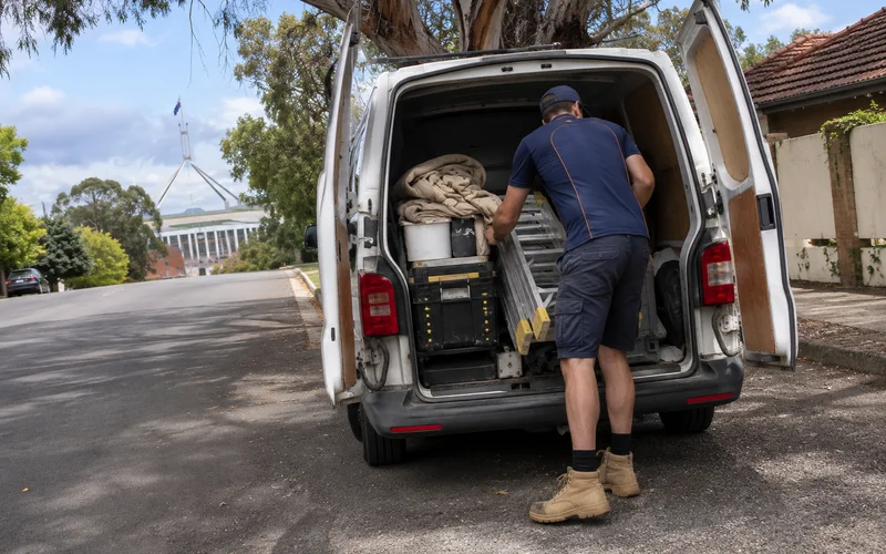 Handyman loading tools into a work van for a multi-job visit