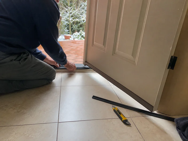 Weather seal being fitted to the bottom of an external door