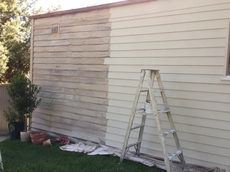 Exterior weatherboard wall half repainted