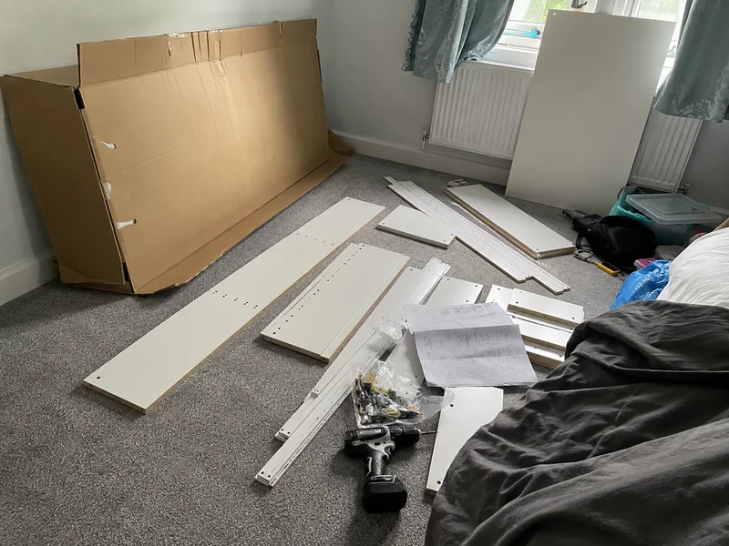 Flat-pack wardrobe parts laid out ready for assembly