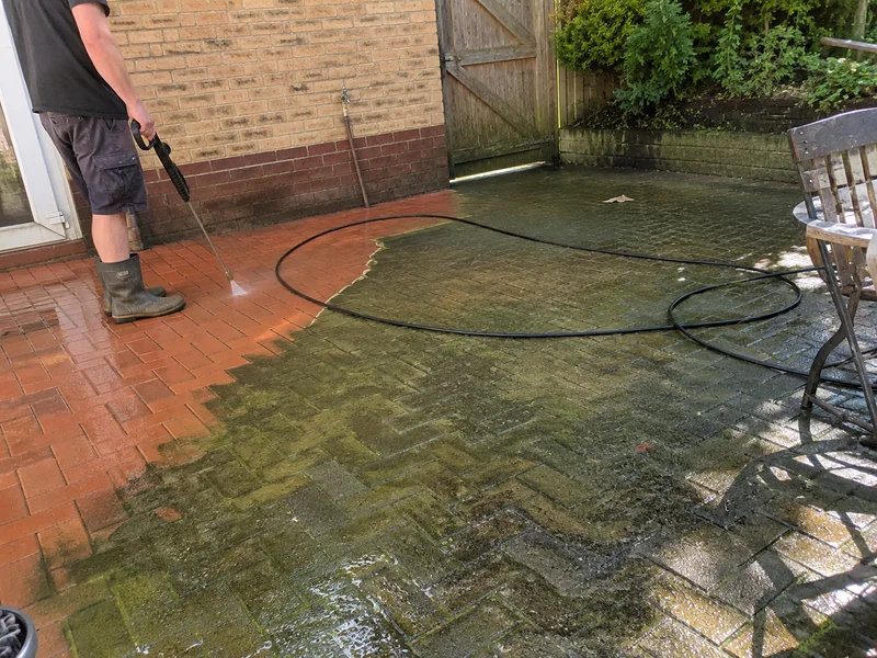 Half-cleaned paved patio showing the difference after washing