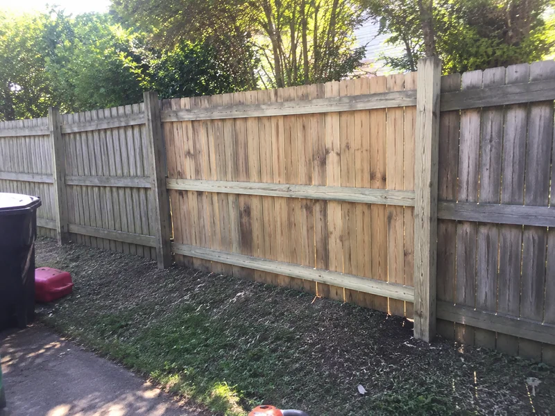 Repaired timber panel fence standing straight along a boundary