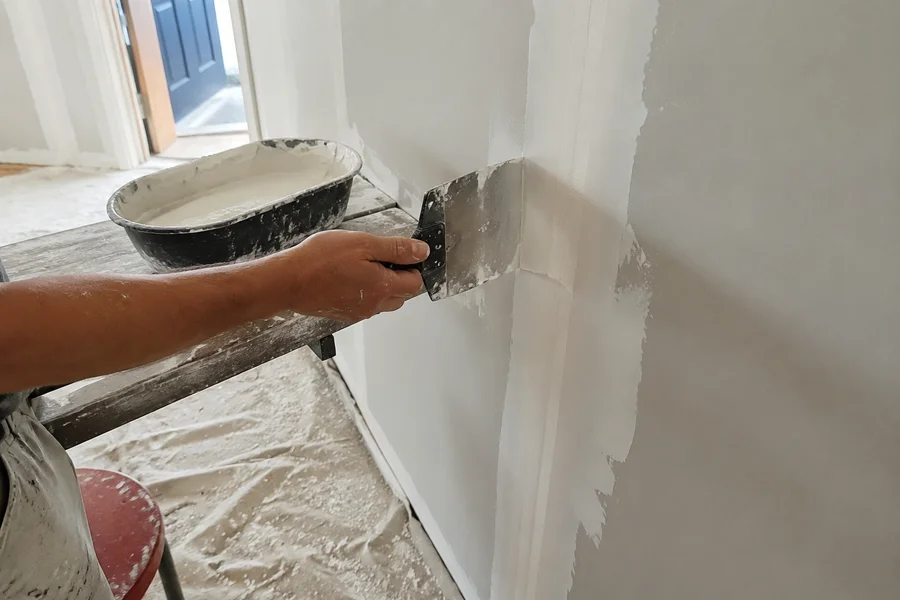 Joint compound feathered over paper tape on a plasterboard repair