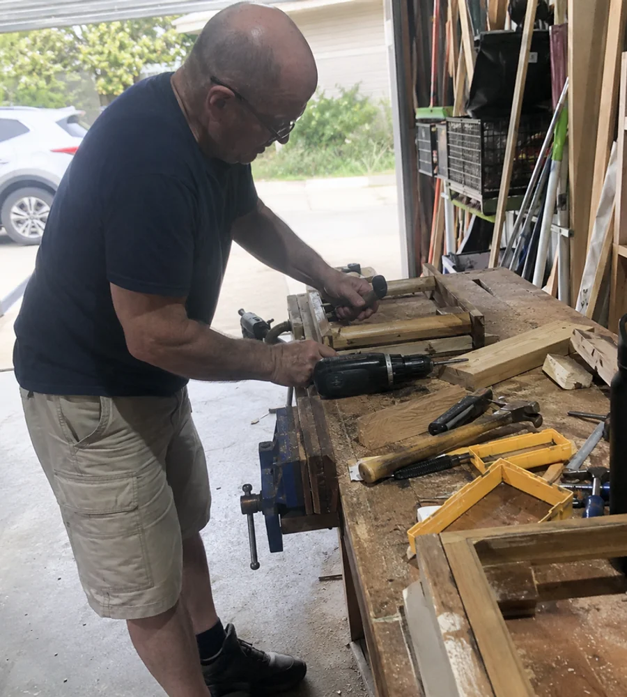 Handyman working at a bench in a home garage workshop