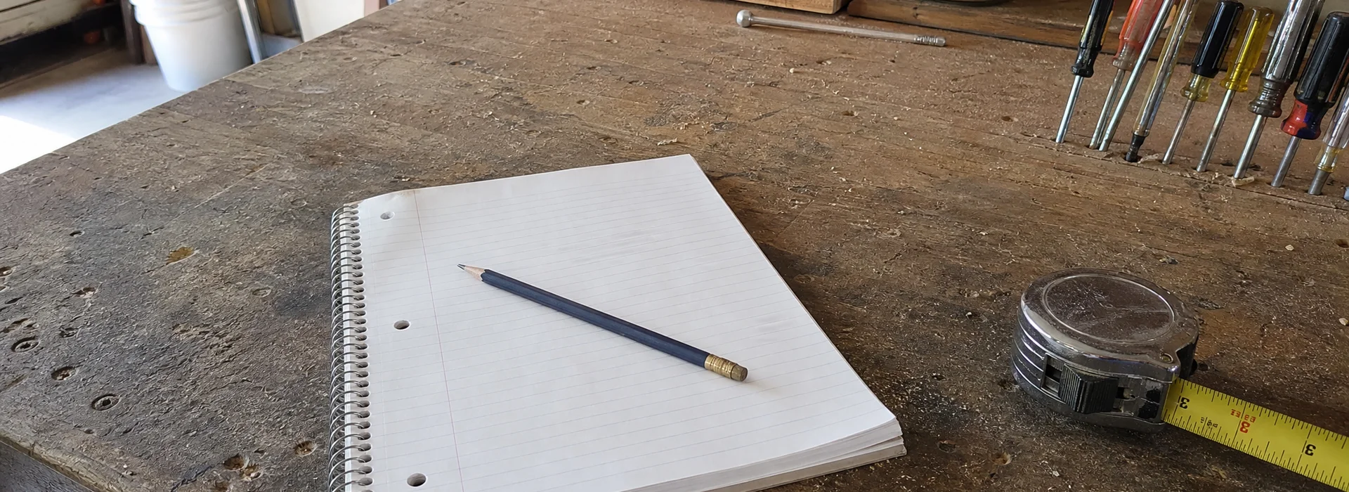 Notepad and tools on a workbench in a home garage workshop